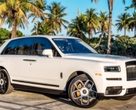 White Rolls-Royce Cullinan Black Badge, front three-quarter view beneath palm trees