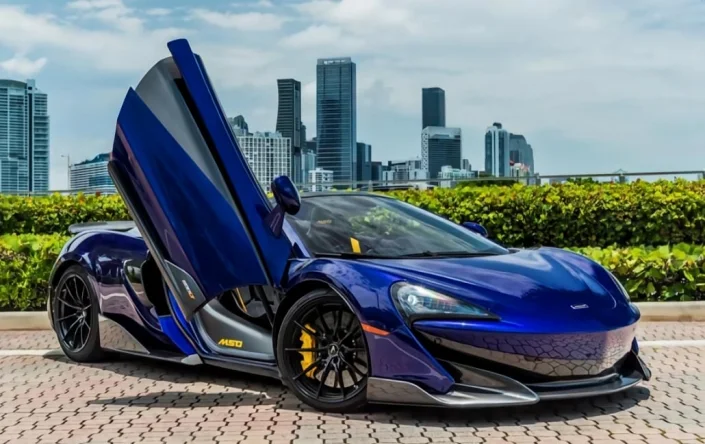 Blue McLaren 600LT — front three-quarter view with a raised door