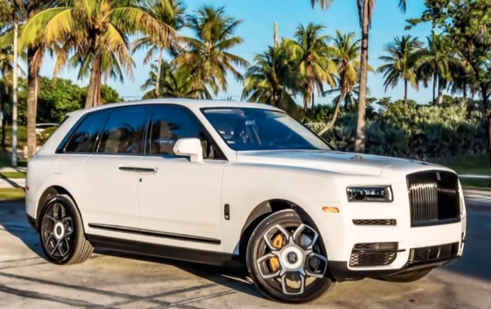 White Rolls-Royce Cullinan Black Badge, front three-quarter view beneath palm trees