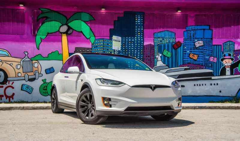 White Tesla Model X beside a mural