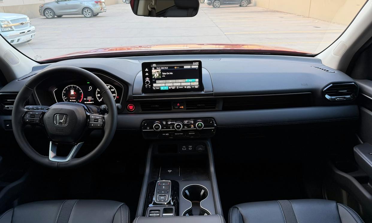 Dashboard and driving controls of the red Honda Pilot EX-L