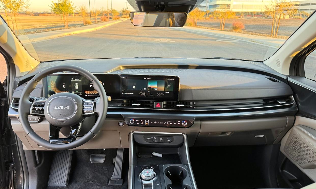 Dashboard and driving controls of the gray Kia Carnival Hybrid LXS