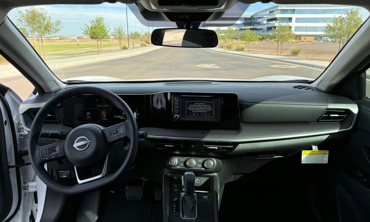 Dashboard and driving controls of the white Nissan Kicks S