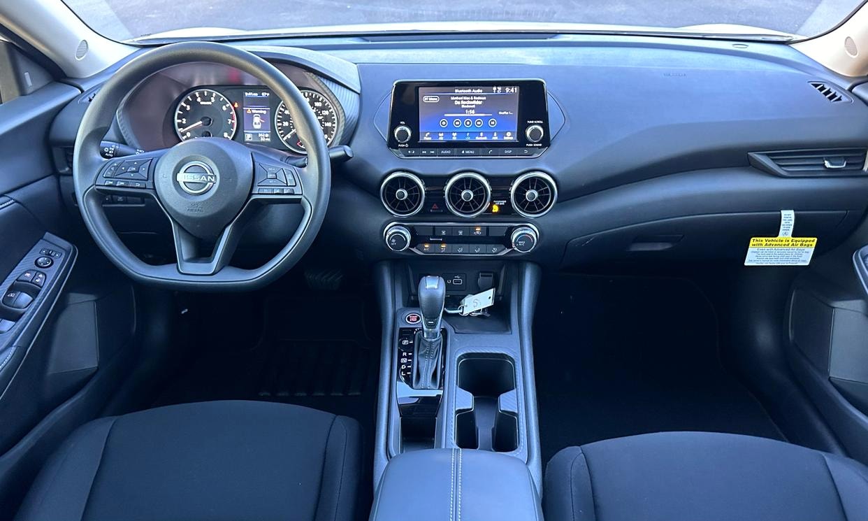 Dashboard and driving controls of the white Nissan Sentra S