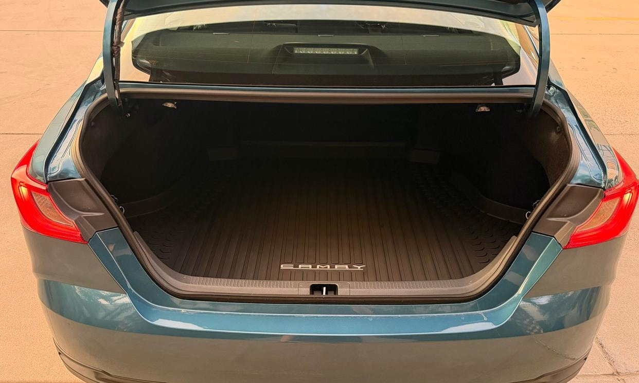 Open cargo area of the blue Toyota Camry Hybrid LE