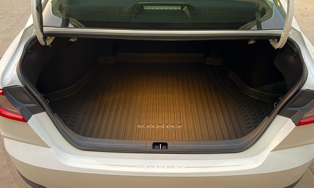 Open cargo area of the white Toyota Camry Hybrid LE