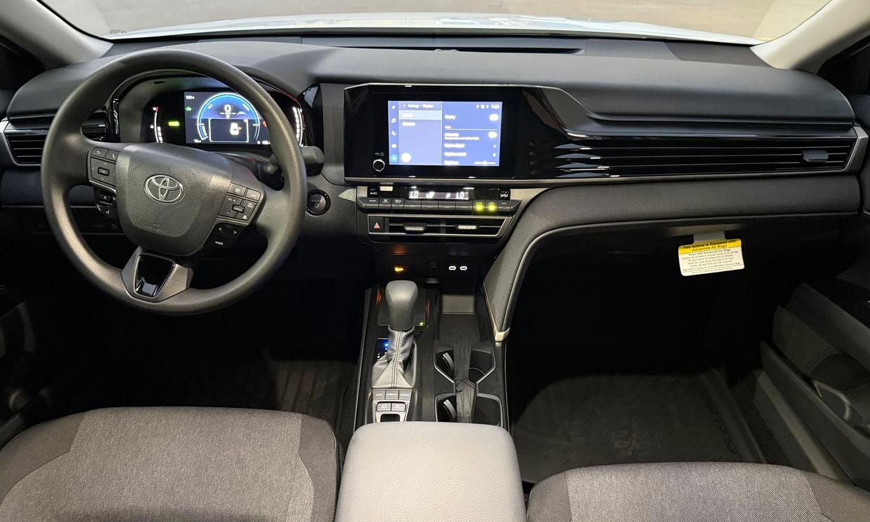 Dashboard and driving controls of the white Toyota Camry Hybrid LE