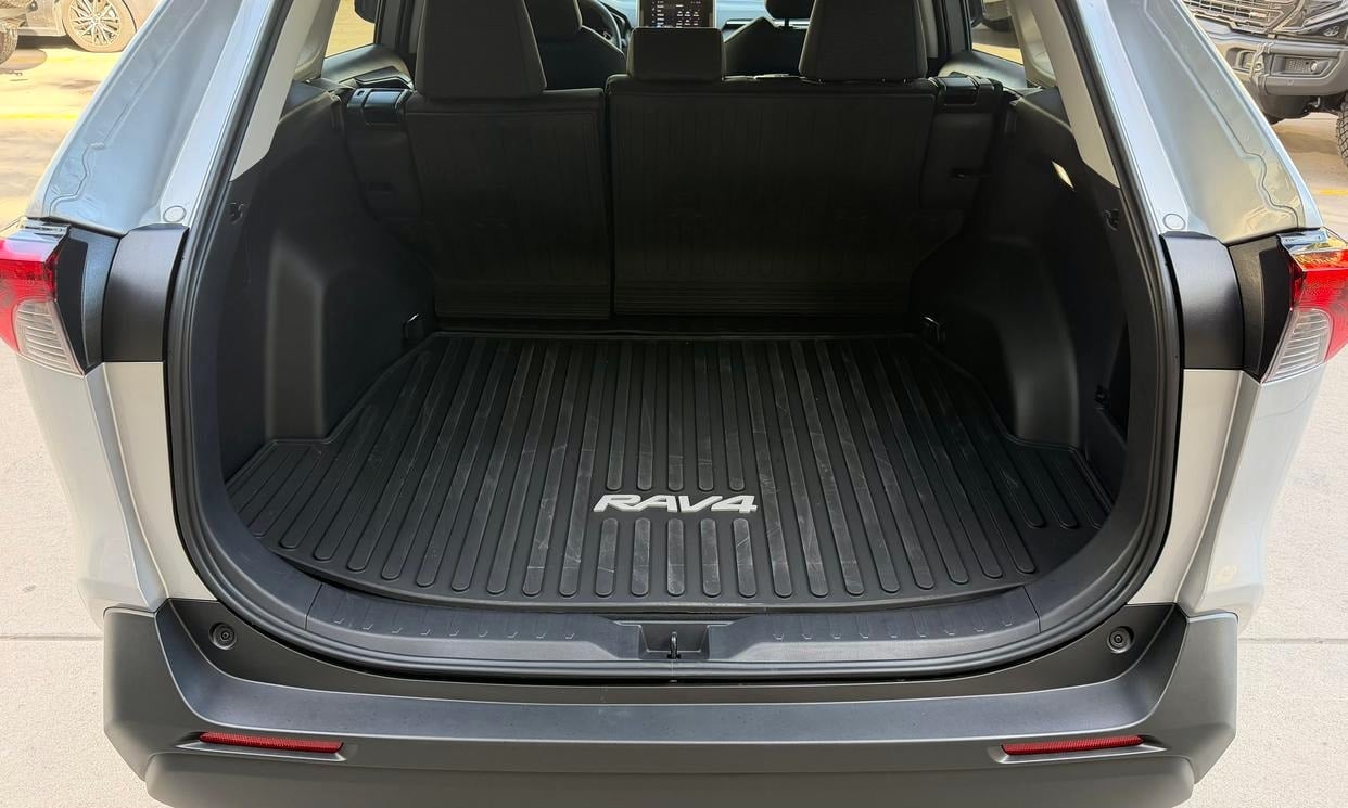 Open cargo area of the silver Toyota RAV4 LE