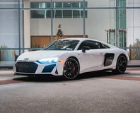 White Audi R8 V10 Performance, front three-quarter view outside a modern building