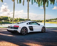 White Audi R8 V10 Performance, rear three-quarter view beside the water