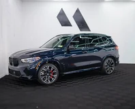 BMW X5 M — Dark blue, front three-quarter view indoors