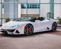 White Lamborghini Huracan EVO Spyder Rental in Miami, front three-quarter view with roof open