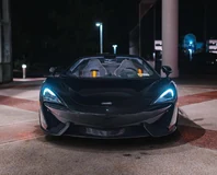 McLaren 570S Spider — Black, front view with roof open