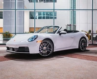 White Porsche 911 Carrera Cabriolet Rental in Miami, front three-quarter view with roof open
